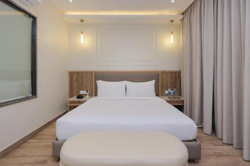 a bedroom with a large white bed and a window at ECKO City Centre Rishikesh in Rishīkesh