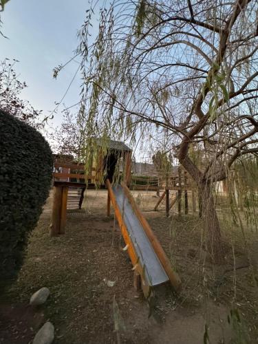 a park with a slide and a tree at El Viento De Mi Sueño in Tafí del Valle