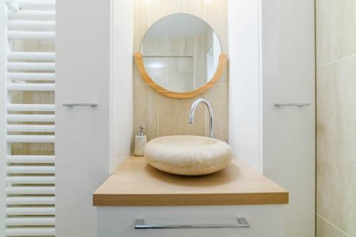 une salle de bain avec un lavabo et un miroir dans l'établissement Appt with Eiffel Tower view at Paris La Defense, à Puteaux