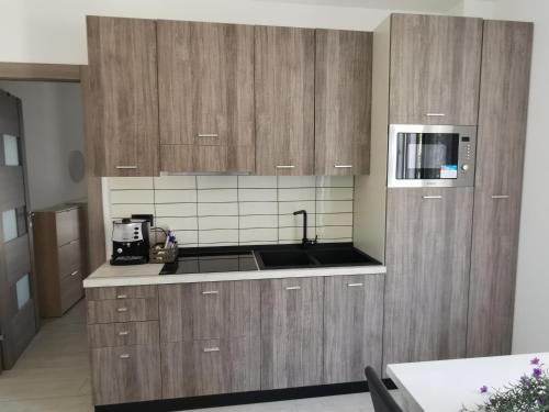 a kitchen with wooden cabinets and a microwave at Tenuta Croce in Salerno