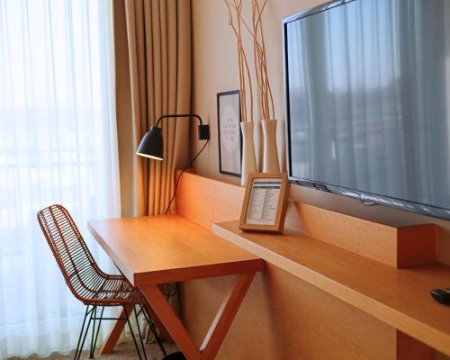 a room with a desk with a television and a chair at SeeHuus Lifestyle Hotel in Timmendorfer Strand