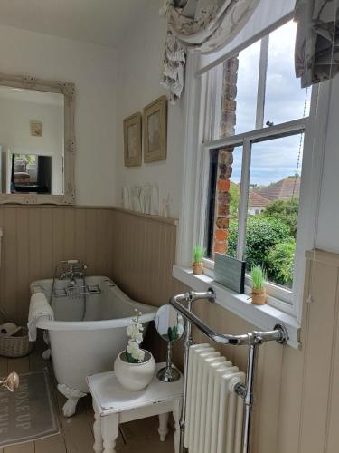 a bathroom with a bath tub and a window at Victorian Retreat - A Serene Sanctuary in Broadstairs