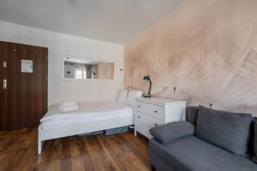 a small bedroom with a bed and a couch at RentPlanet - Studio Rynek Ratusz in Wrocław