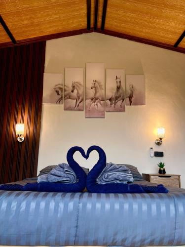 a bedroom with a bed with two swans making a heart at Camping phutajoy Khaosok แคมป์ปิ้งภูตาจ้อยเขาศก in Ban Thung Lang Tham
