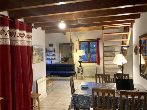 a living room with a table and a blue couch at Chalet Parc des Écrins in Le Petit-Parcher