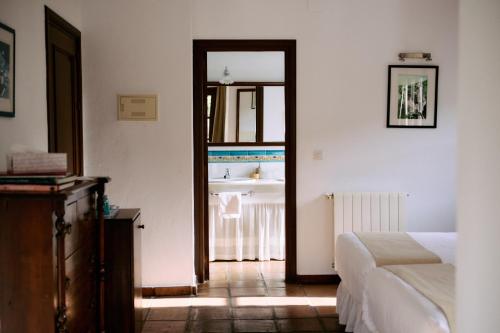 a bedroom with a bed and a door to a bathroom at Molino Del Santo in Benaoján