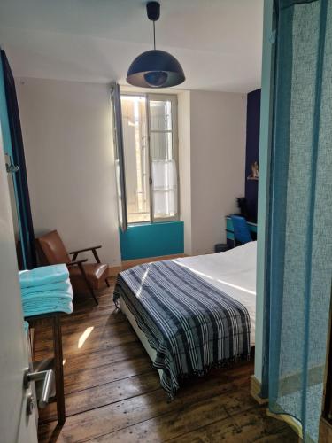 un dormitorio con una cama y una ventana en Le jardin aux camélias, en La Roche-sur-Yon