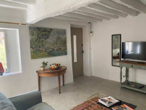 un salon avec une table et une télévision dans l'établissement Le Domaine Saint Jean, à Saint-Saturnin-lès-Apt