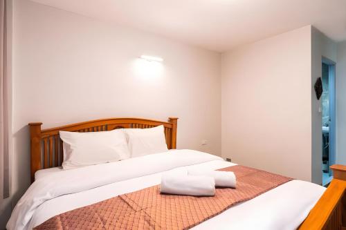 a bedroom with a large bed with white pillows at GO INN Khaosan - โกอินน์ ถนนข้าวสาร in Bang Bua Thong Railway Station