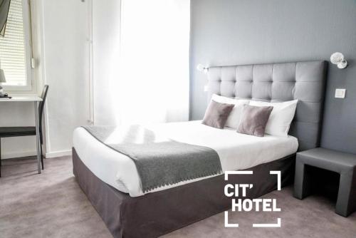 a bedroom with a king sized bed and a chair at Cit'Hôtel l'Europe - Cholet Gare in Cholet