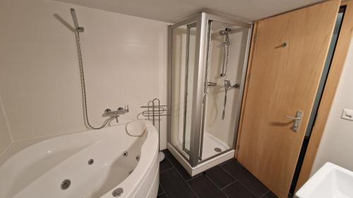 a white bath tub in a bathroom with a shower at Mountain Village Chalet in Saas-Fee
