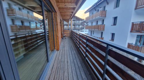 a balcony with a wooden walkway in a building at Derby in Saas-Fee