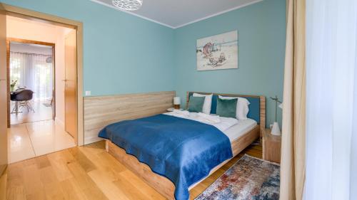 a bedroom with a large bed with blue sheets at Leśne Zacisze, Sun & Snow in Świnoujście