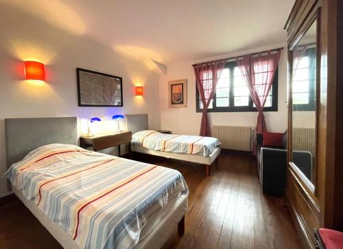 a hotel room with two beds and two windows at Bernet in Labastide-Villefranche