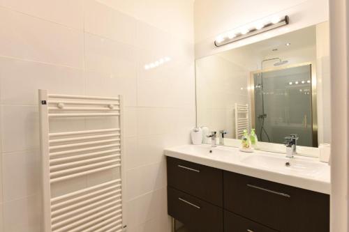 a white bathroom with a sink and a mirror at Bernet in Labastide-Villefranche