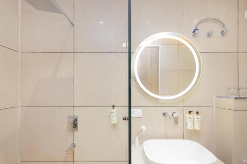 a bathroom with a shower with a sink and a mirror at ECKO City Centre Rishikesh in Rishīkesh