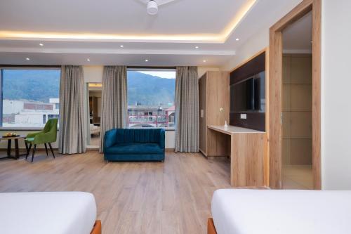 a room with a bed and a couch and a tv at ECKO City Centre Rishikesh in Rishīkesh
