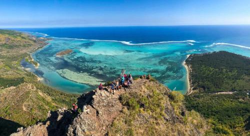a group of people standing on the edge of a mountain at Les Pêcheurs in Le Morne