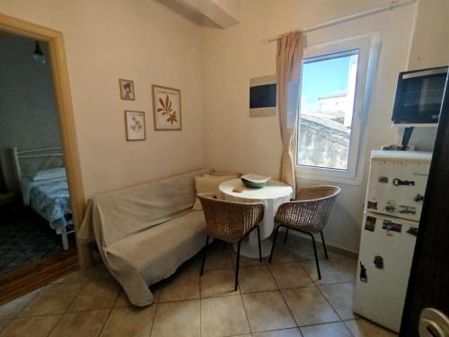 a small living room with a table and chairs at Antigoni old town Apartment in Corfu
