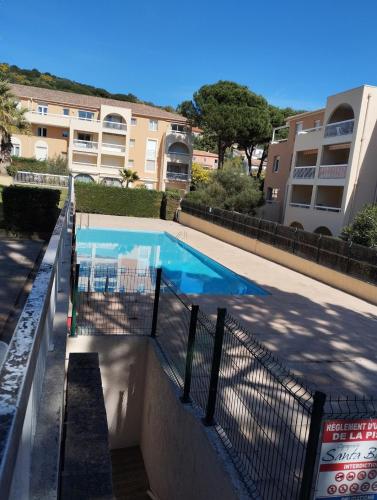 une piscine devant un immeuble dans l'établissement T3 cavalaire dans résidence avec piscine, à Cavalaire-sur-Mer
