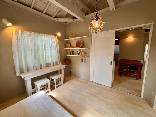 石垣島にあるMi Casa みいかあさのベッドとテーブルとシャンデリアのある寝室