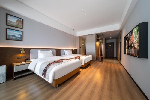 a hotel room with two beds and a tv at Yongchun Laimeng Garden Hotel in Yung-ch'un-hsien