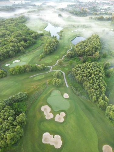 an aerial view of a golf course with trees and water at Zala Springs Golf Resort in Zalacsány