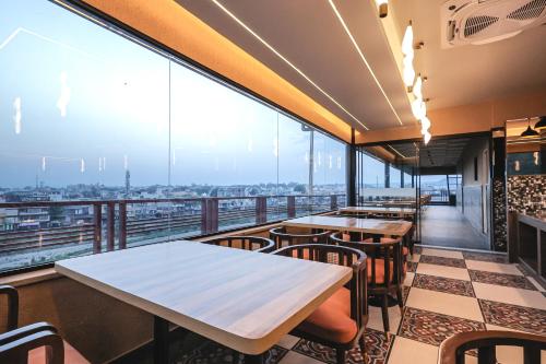 a restaurant with tables and chairs on a balcony at ECKO City Centre Rishikesh in Rishīkesh