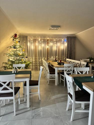a restaurant with a christmas tree and tables and chairs at Willa Wioletta in Tylmanowa