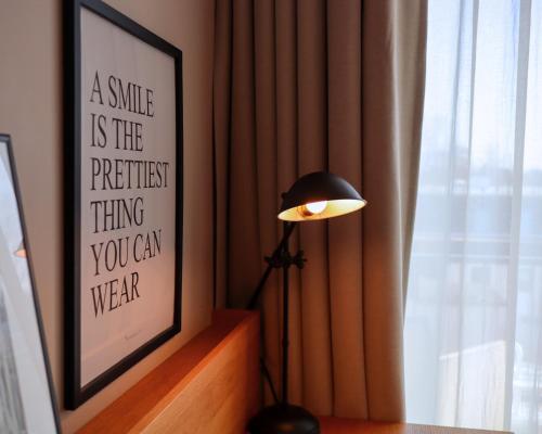 a lamp in a room next to a window with a picture at SeeHuus Lifestyle Hotel in Timmendorfer Strand