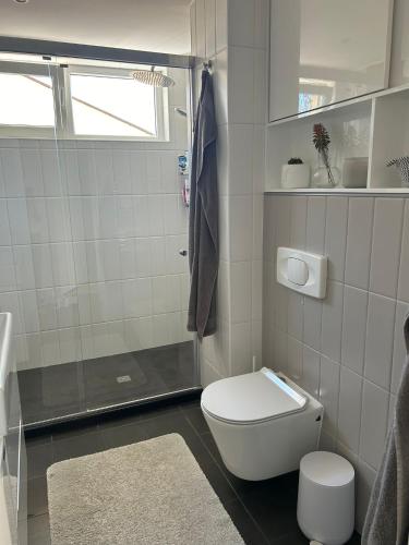 a white bathroom with a shower and a toilet at Leni in Ruse