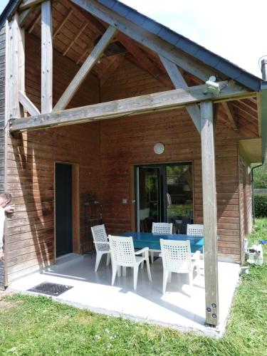 d'une terrasse avec une table bleue et des chaises blanches. dans l'établissement Le chalet Martin - 400 mètres de la plage, à Plérin