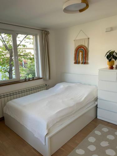 a bedroom with a white bed and a window at Leni in Ruse
