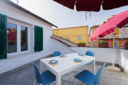 a white table and blue chairs on a patio at the riviera attico terrazza in Lavagna