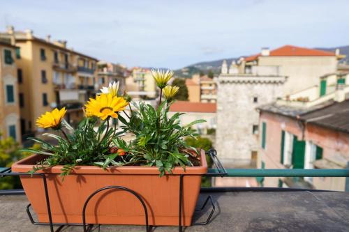 a planter with flowers sitting on top of a balcony at the riviera attico terrazza in Lavagna