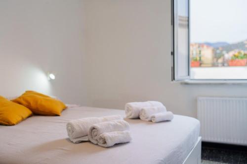 two rolled towels on a bed in a room at the riviera attico terrazza in Lavagna