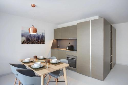a kitchen and dining room with a wooden table and chairs at Contemporary Cosy Central Studio in Nyon - RM8 in Nyon