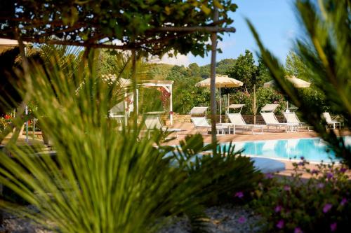 a swimming pool with chairs and a table and a pool at Cuore del Cilento Relais&Retreat in Castellabate