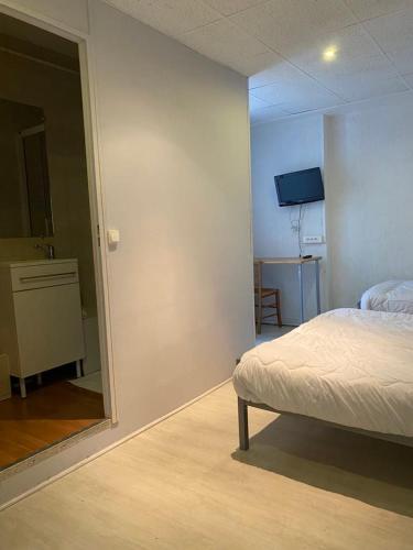 a bedroom with a bed and a mirror in it at Hotel Du Commerce in Auxerre
