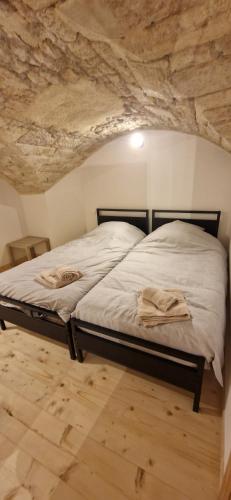 un lit dans une chambre avec un mur en pierre dans l'établissement Appartement tout confort, à Montlebon