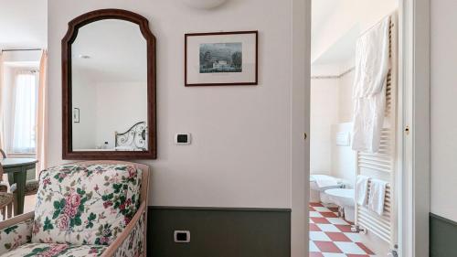 een kamer met een stoel en een spiegel bij Residence la Limonera in Bellagio