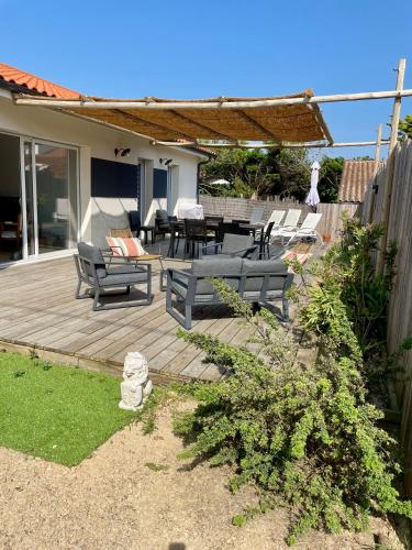 d'une terrasse avec des bancs, une table et des chaises. dans l'établissement Villa Océane, à Mimizan-Plage