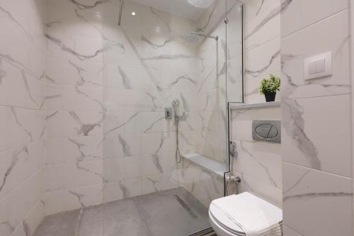 a white bathroom with a shower and a toilet at Immense appartement 6pièces au Golf in El Mouradia