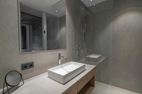 a bathroom with a white sink and a mirror at Seehotel Bellevue by keyone in Zell am See