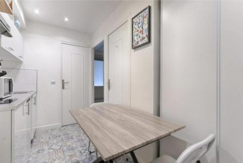 - une cuisine avec une table en bois dans une chambre dans l'établissement Bastille Republique Charming & Cosy Apartment 1BR, à Paris
