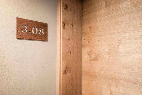 a wooden door with a sign on the wall at The Post Apartments in Dobbiaco