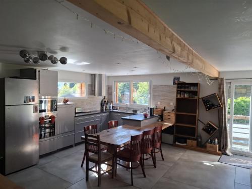 une cuisine avec une table, des chaises et un réfrigérateur dans l'établissement Chalet du Verney - Pied du Prarion - Sauna, aux Houches