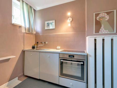 沃尔特湖畔韦尔登Ferienwohnung mit traumhaftem Seeblick的一个小厨房，里面有水槽和炉灶。