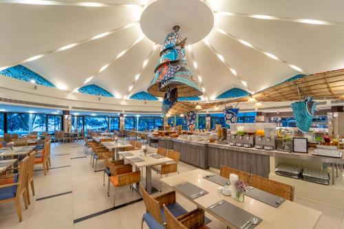 a restaurant with tables and chairs and a bar at Springfield @Sea Resort & Spa in Cha Am