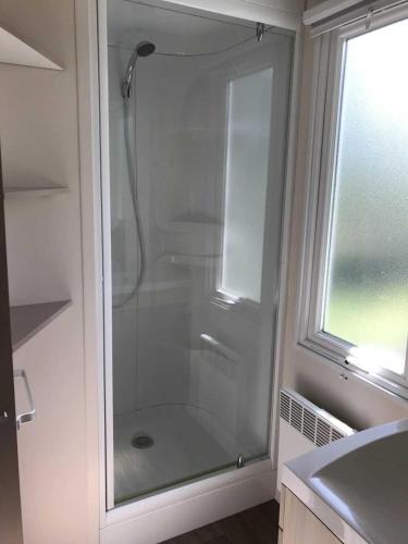 La salle de bains est pourvue d'une douche en verre et d'une fenêtre. dans l'établissement Camping 3 étoiles - Piscine - ccbbhgd, à Peynier